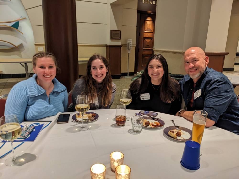 Four teachers pose for a photo at a table